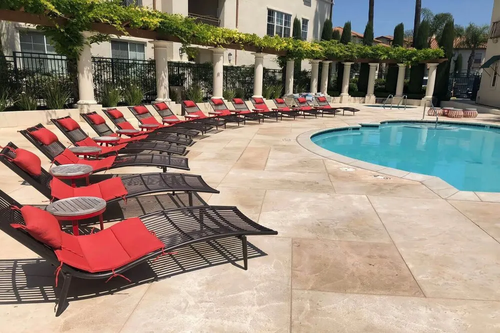 Red cushioned lounge chairs by pool