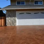 Stamped concrete driveway and white garage door