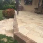 Stone tiled backyard patio with steps