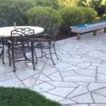 Backyard stone patio with table and firepit