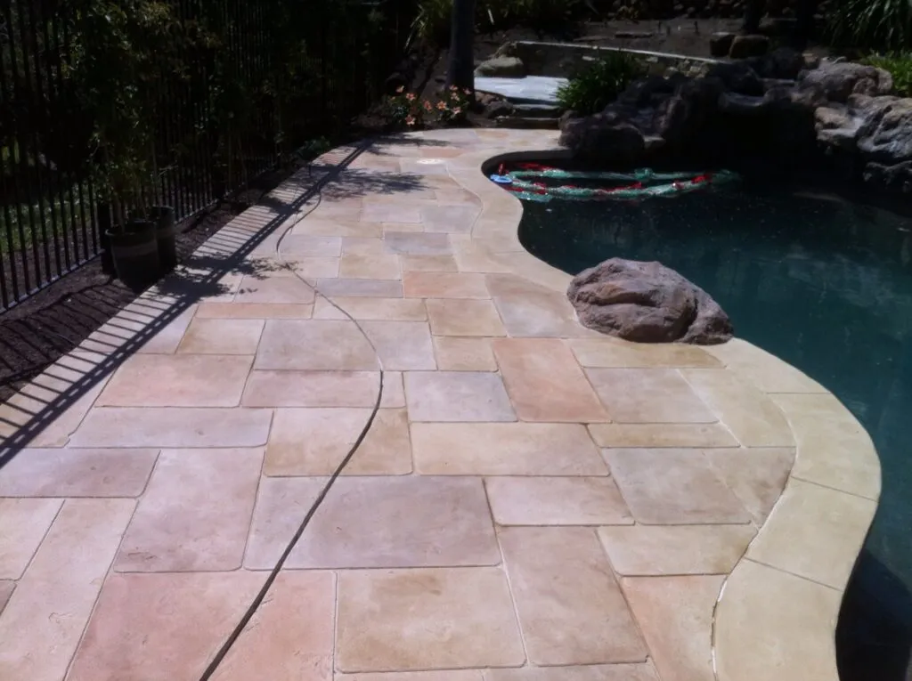 Curved stone pool deck with rock feature