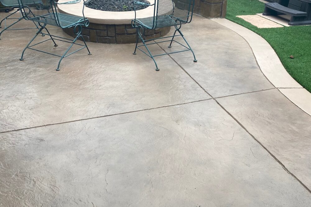 Concrete patio with metal chairs and planter